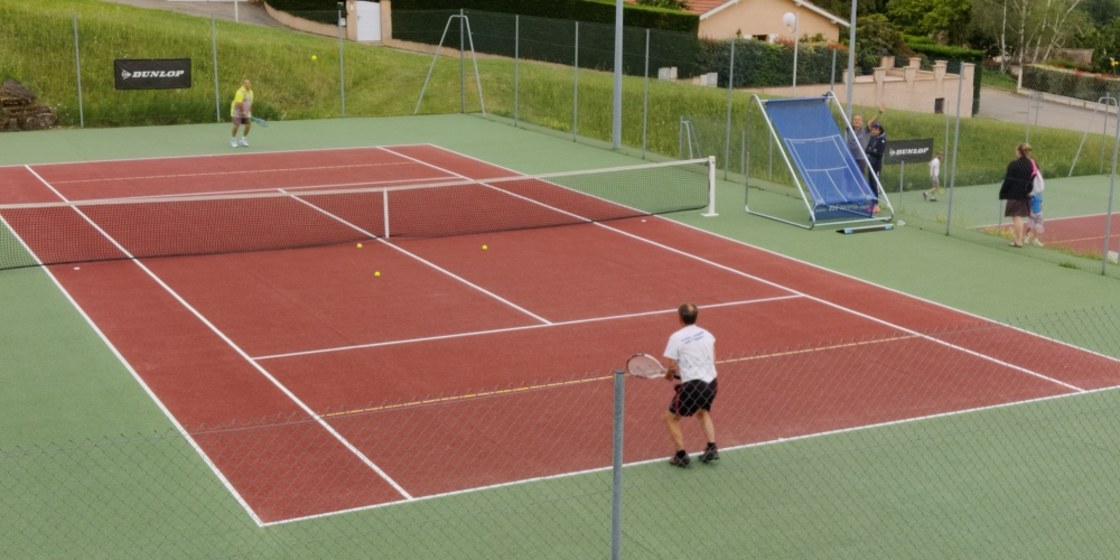 Court n°1 du TCSM en béton poreux avec joueurs et panneau d'entraînement Dunlop